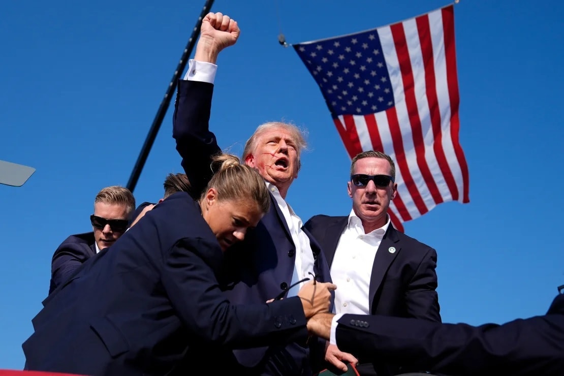 Ông Donald Trump được mật vụ Mỹ hộ tống khỏi hiện trường sau vụ nổ súng ở bang Pennsylvania ngày 13-7. Ảnh: AP