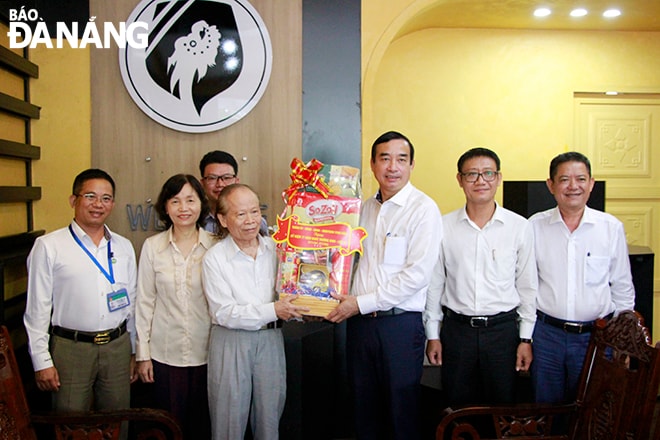 Chủ tịch UBND thành phố Lê Trung Chinh (thứ 3, bên phải sang) tặng quà cho gia đình thương binh 3/4 Ngô Chí Nguyện. Ảnh: X.D