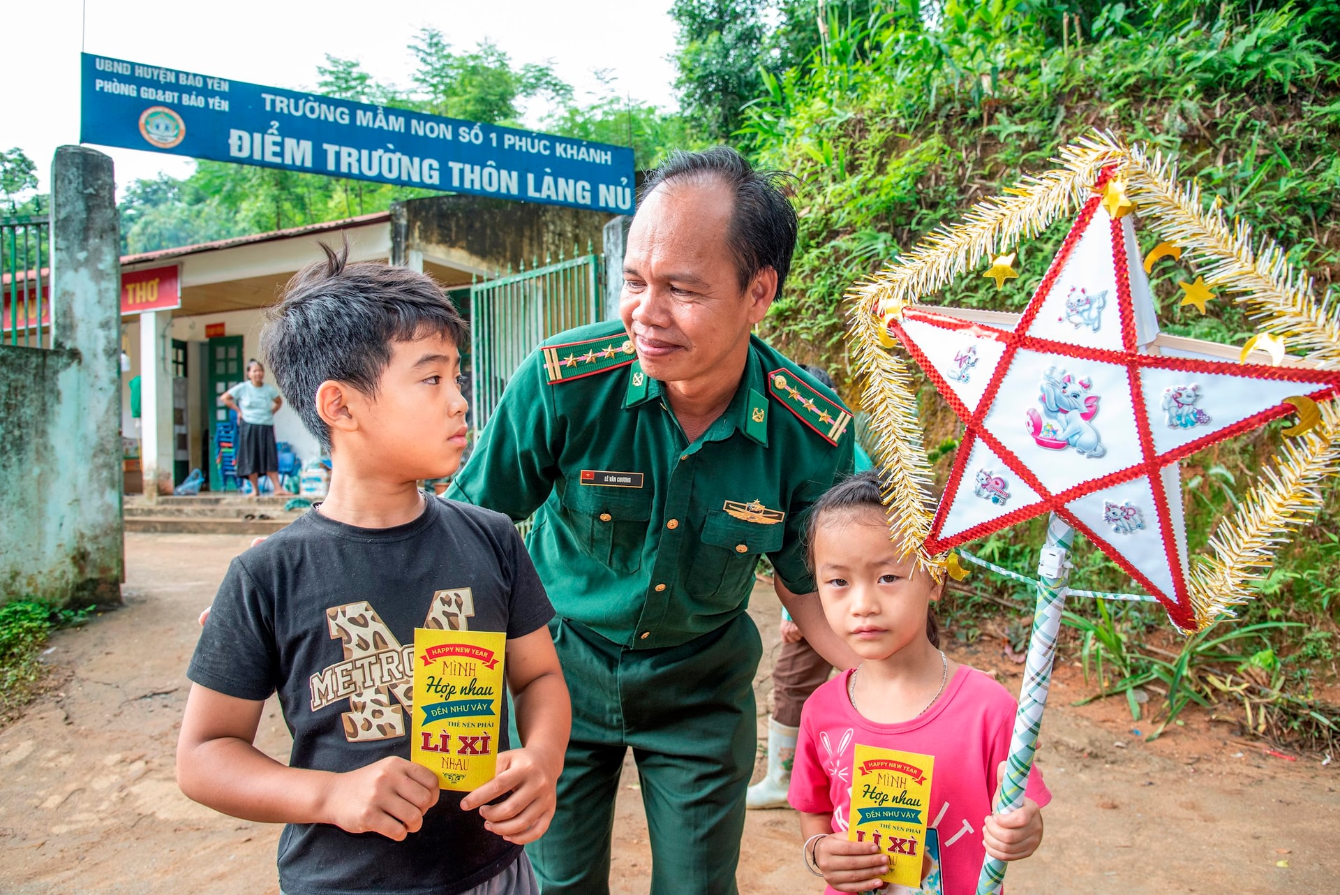 Nhà báo Lê Văn Chương trao món quà cho phóng viên báo Quảng Nam cho trẻ em thôn Làng Nủ