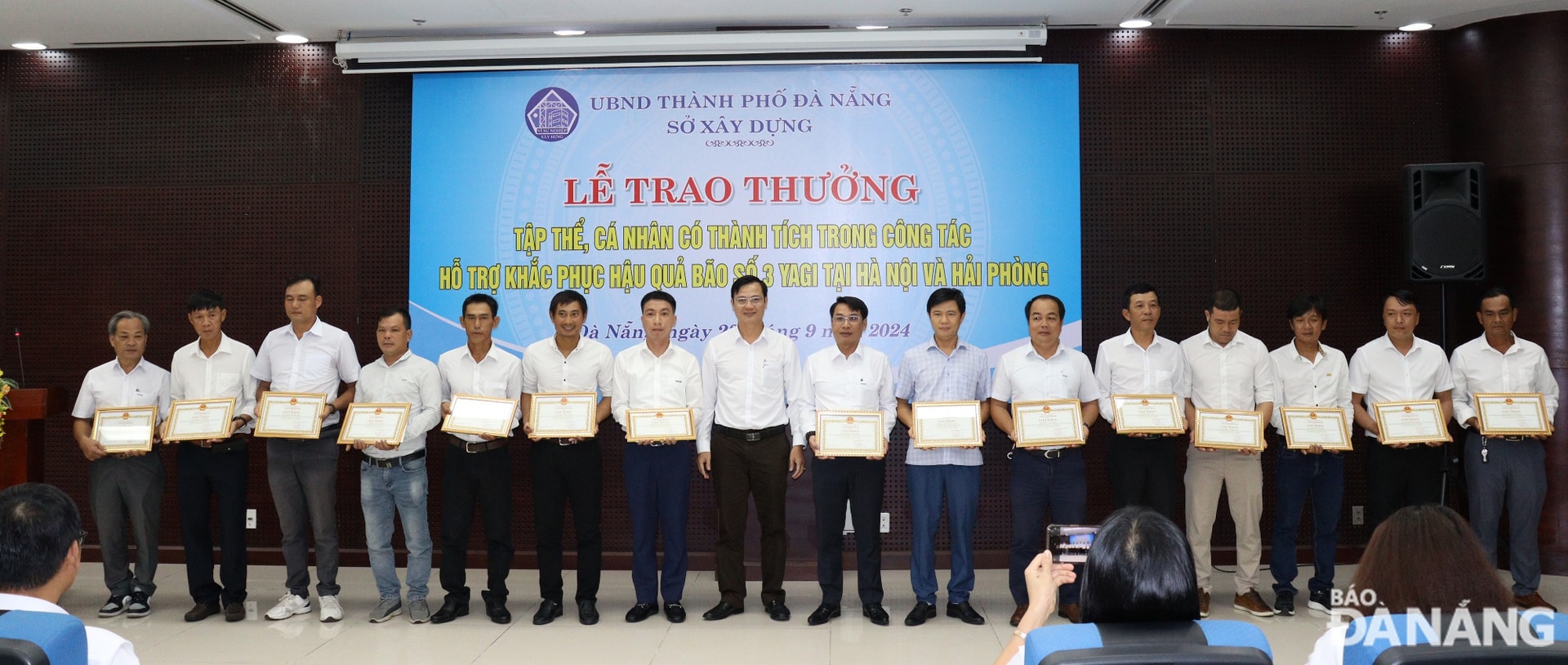 Phó Giám đốc Sở Xây dựng Lê Văn Tuấn (thứ 8, từ trái sang) trao giấy khen của Giám đốc sở cho các cá nhân tham gia hỗ trợ khắc phục hậu quả bão số 3 (Yagi) tại thủ đô Hà Nội và thành phố Hải Phòng. Ảnh: HOÀNG HIỆP