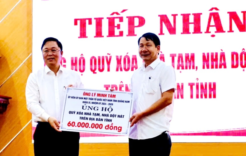 Chủ tịch Ủy ban MTTQ Việt Nam tỉnh Lê Trí Thanh (bên trái) tiếp nhận bảng tượng trưng ủng hộ 60 triệu đồng từ ông Lý Minh Tám. Ảnh: PV