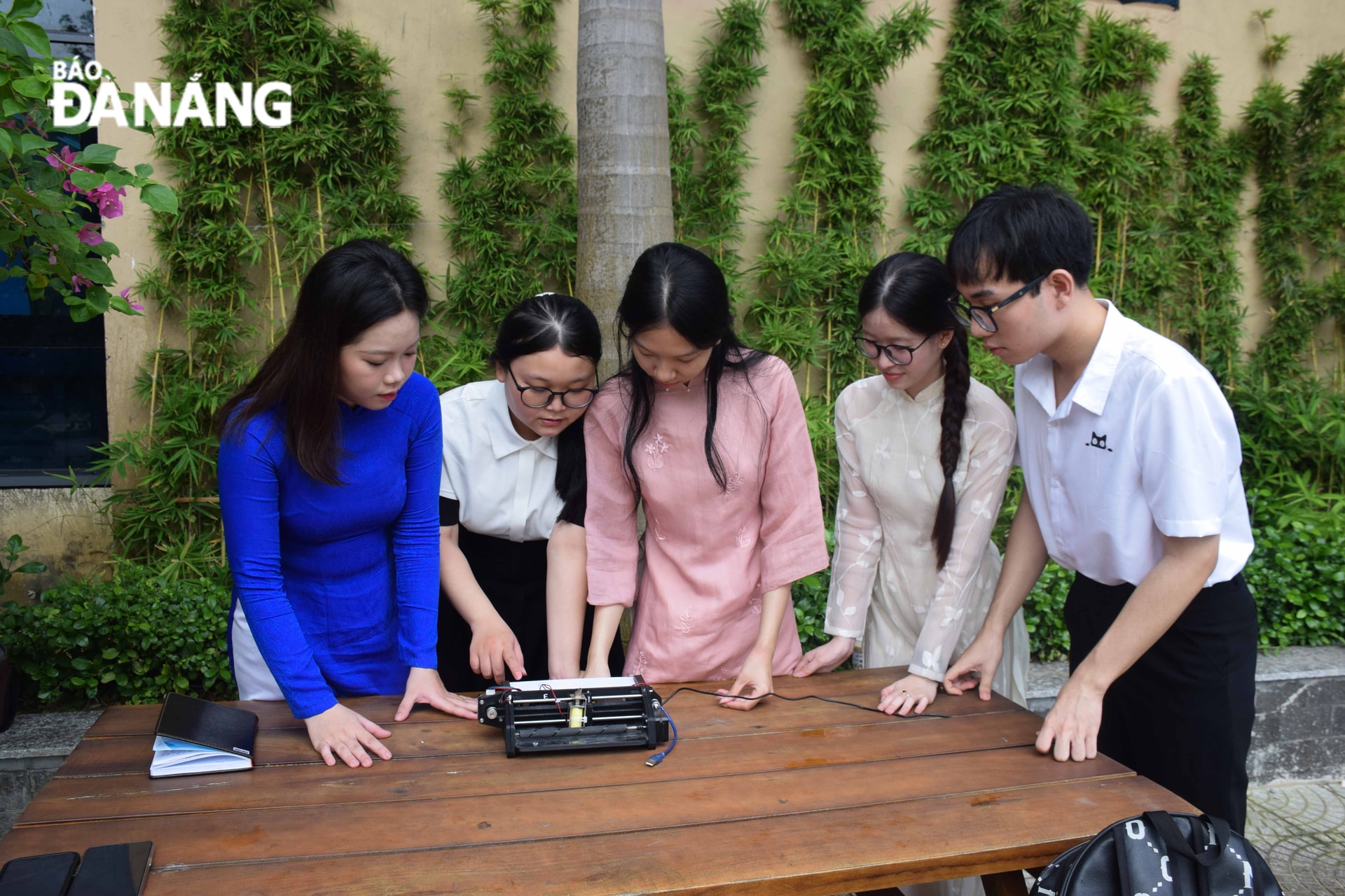 Sinh viên Lê Thanh Trúc cùng nhóm nghiên cứu của mình kiểm tra lại hoạt động của chiếc máy in chữ nổi sau khi chế tạo. Ảnh: Đ.H.L