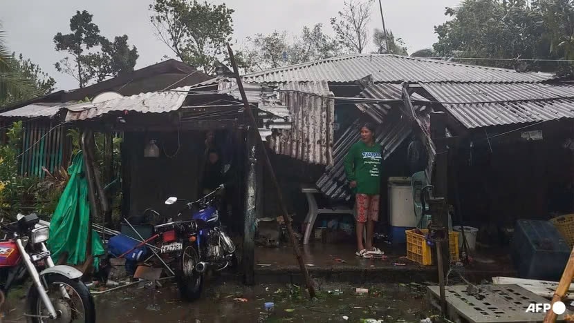 Nphụ nữ bên ngoài ngôi nhà bị hư hại ở Dilasag vào ngày 11/11 sau khi cơn bão Toraji đổ bộ vào bờ biển đông bắc của Philippines. Ảnh: AFP