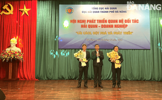 Thừa ủy quyền của Tổng cục trưởng Tổng cục Hải quan, Phó Chủ tịch Thường trực UBND thành phố Hồ Kỳ Minh trao kỷ niệm chương của Tổng cục Hải quan cho 2 tập thể. Ảnh: M.QUẾ