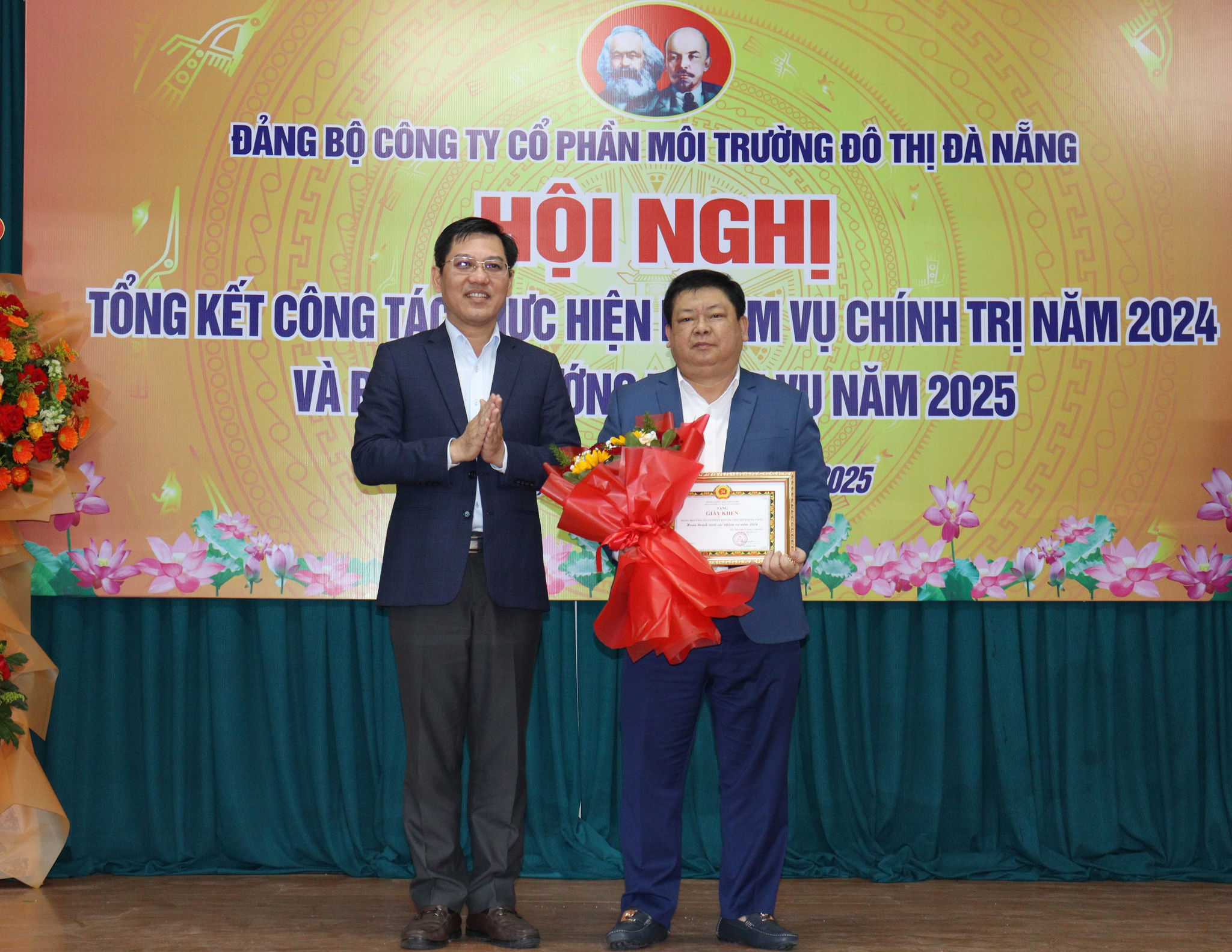 Lãnh đạo Quận ủy Hải Châu tặng giấy khen của Bí thư Quận ủy cho Đảng bộ Công ty CP Môi trường đô thị Đà Nẵng. Ảnh: PHƯƠNG VŨ