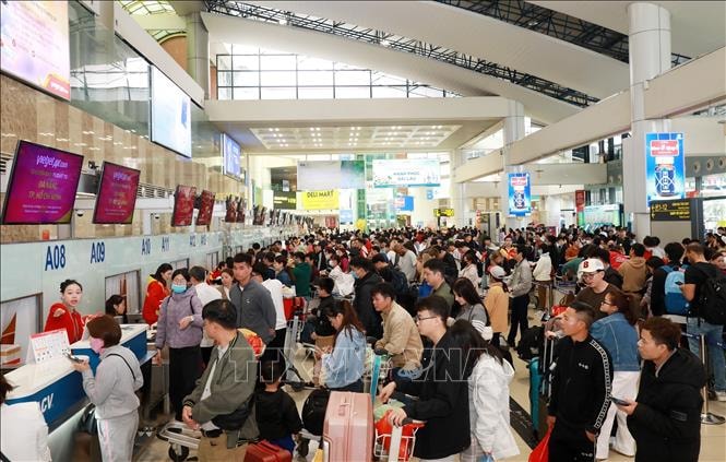 Người dân xếp hàng đông nghẹt chờ làm thủ tục tại quầy của hãng hàng không Vietjet ở sân bay quốc tế Nội Bài, sáng mùng 5 Tết Ất Tỵ. Ảnh: Quốc Khánh/TTXVN