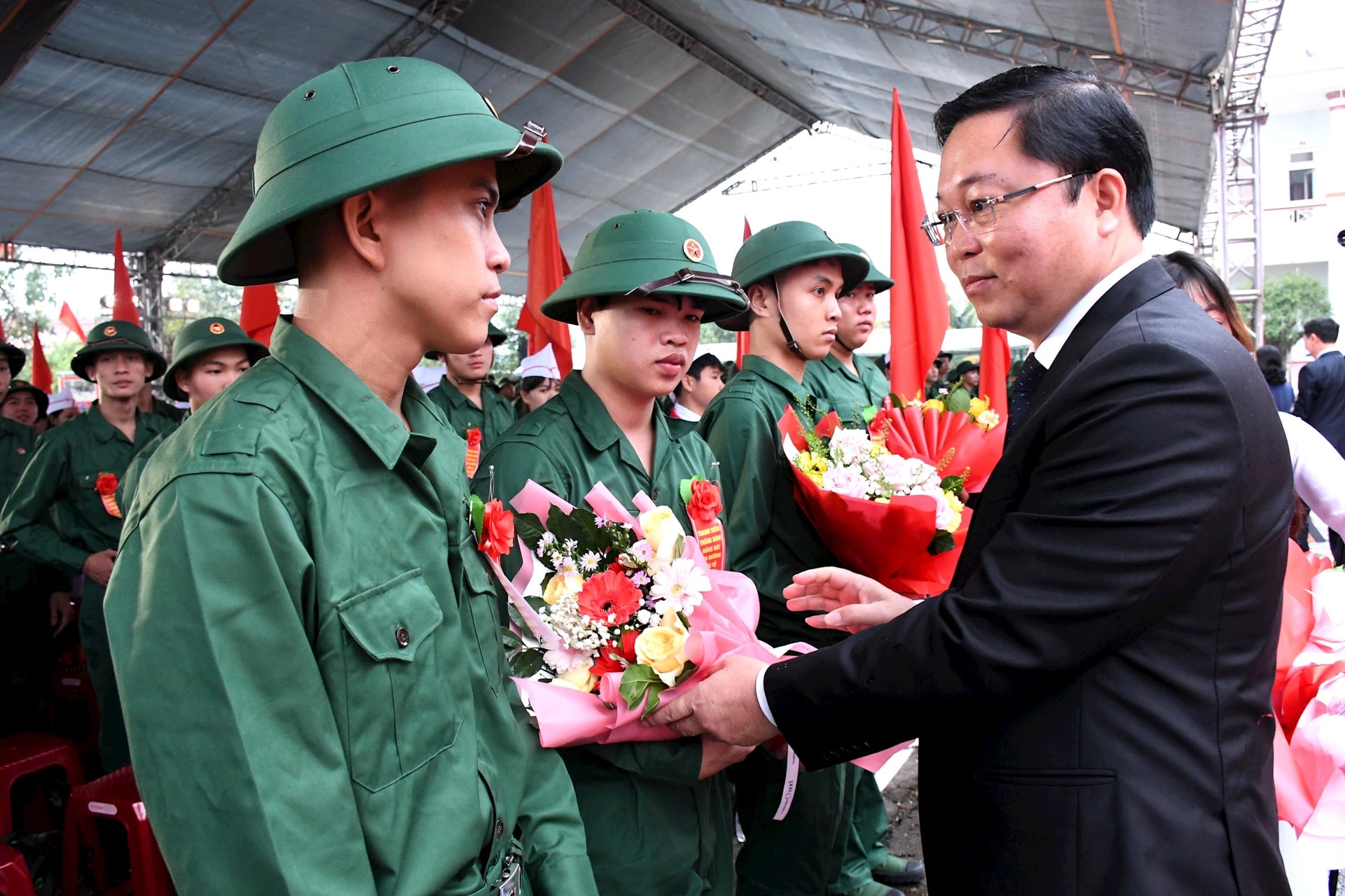 Chủ tịch Ủy ban MTTQ Việt Nam tỉnh Lê Trí Thanh tặng hoa, động viên thanh niên lên đường nhập ngũ. Ảnh QUANG VIỆT