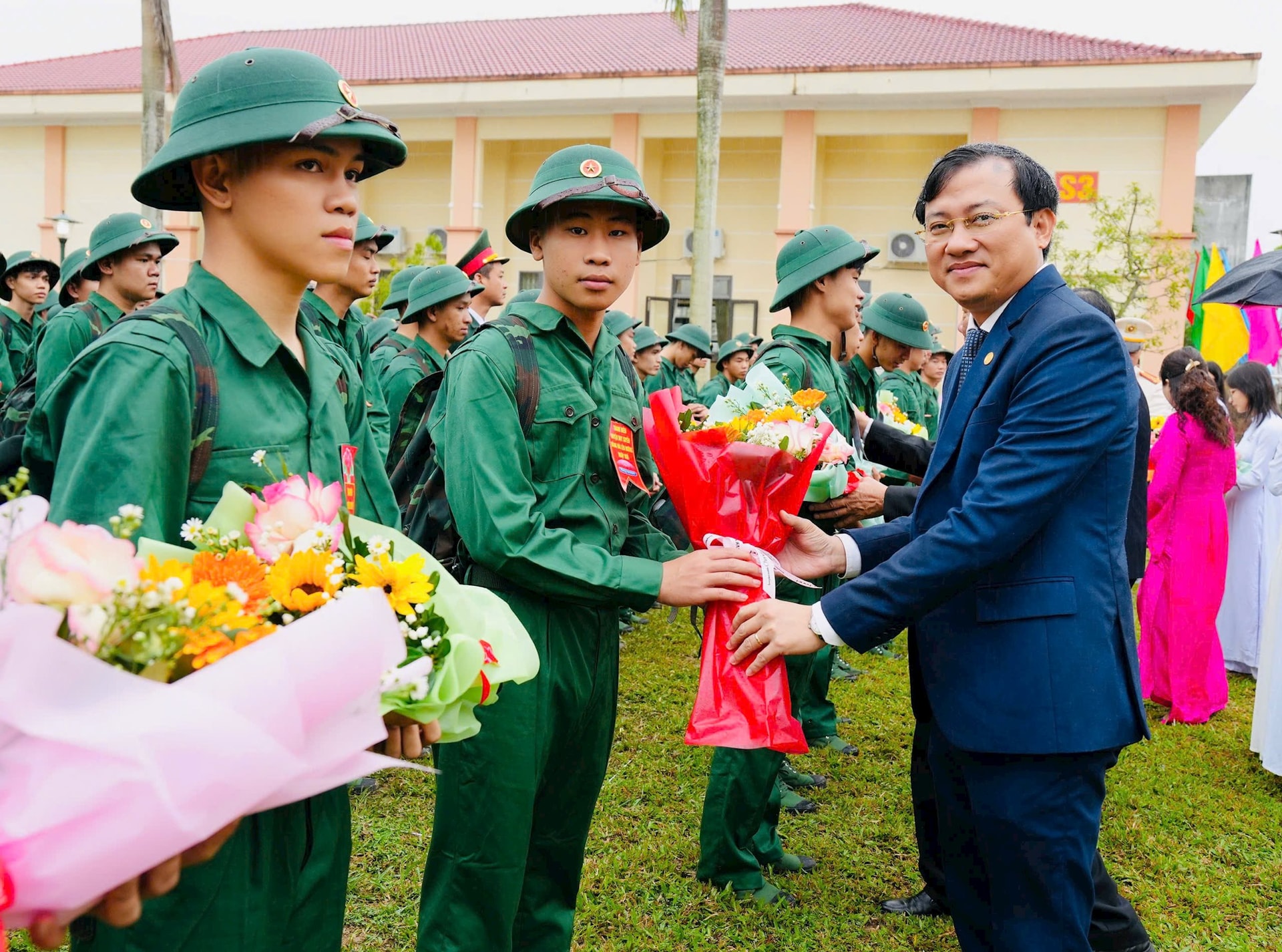 Đồng chí Phan Văn Bình - Trưởng ban Tổ chức Tỉnh ủy tặng hoa động viên tân binh. Ảnh PHI THÀNH