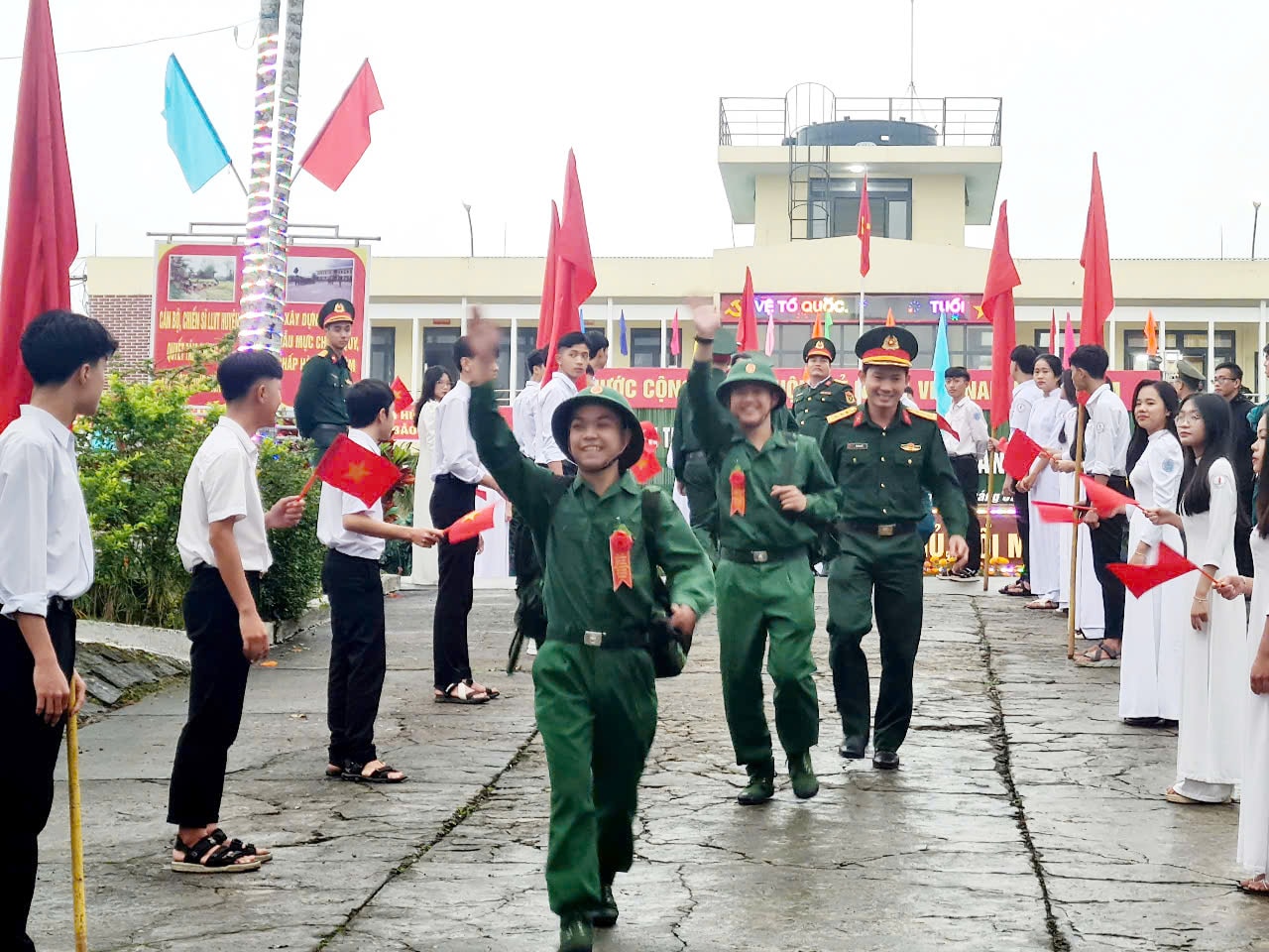 Thanh niên vẫy tay chào tạm biệt người thân trước giờ lên xe về đơn vị. Ảnh DIỄM LỆ