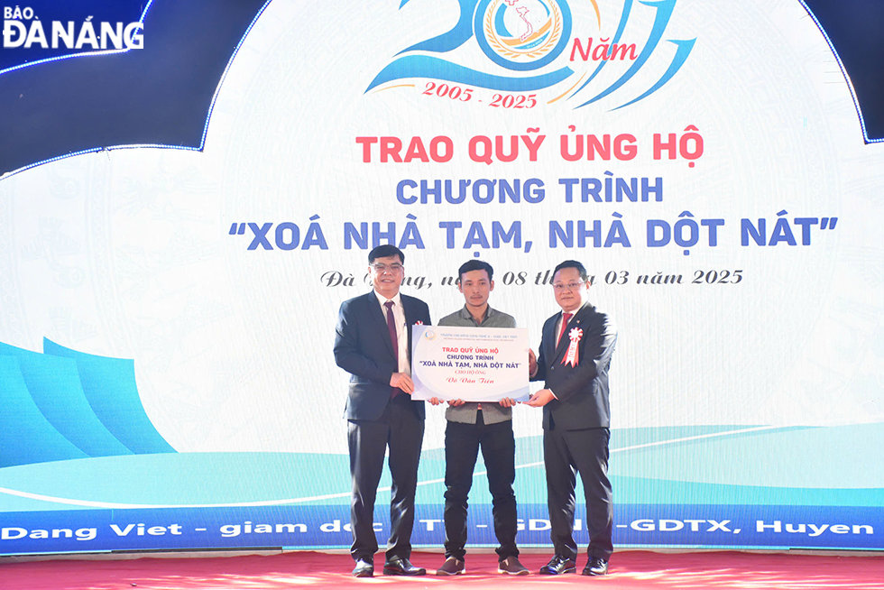 Phó Chủ tịch Ủy ban MTTQ Việt Nam Nguyễn Đăng Hoàng cùng đại diện nhà trường trao quỹ ủng hộ chương trình Xóa nhà tạm, nhà dột nát. Ảnh: THU HÀ