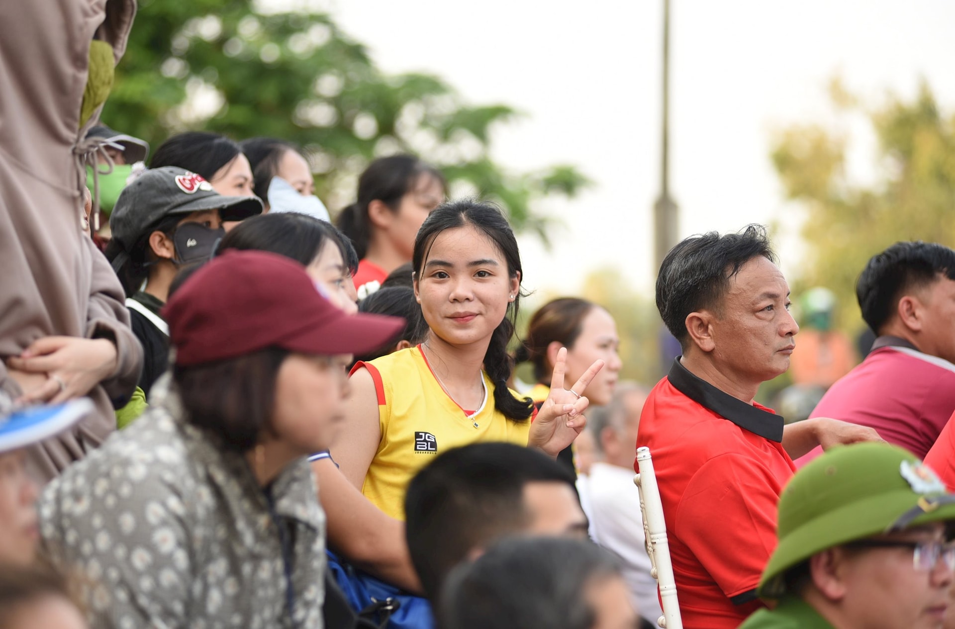 Trong khi chờ thi đấu, một vận động viên đội Quế Sơn trở thành khán giả. Ảnh: TƯỜNG VY