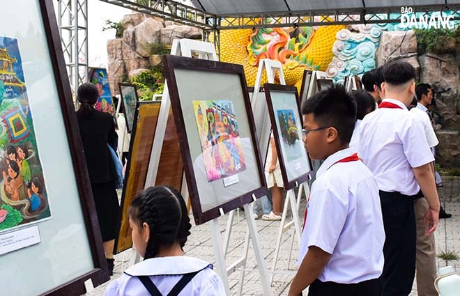 Các em học sinh tham quan triển lãm tranh thiếu nhi “Ngũ Hành Sơn - Mùa lễ hội”. Ảnh: ĐOÀN HẠO LƯƠNG
