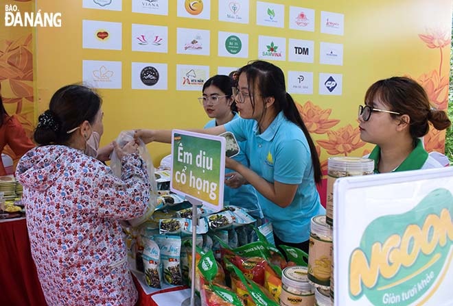 Du khách mua hàng tại gian hàng OCOP giới thiệu sản phẩm đặc trưng của thành phố Đà Nẵng. Ảnh: ĐOÀN HẠO LƯƠNG