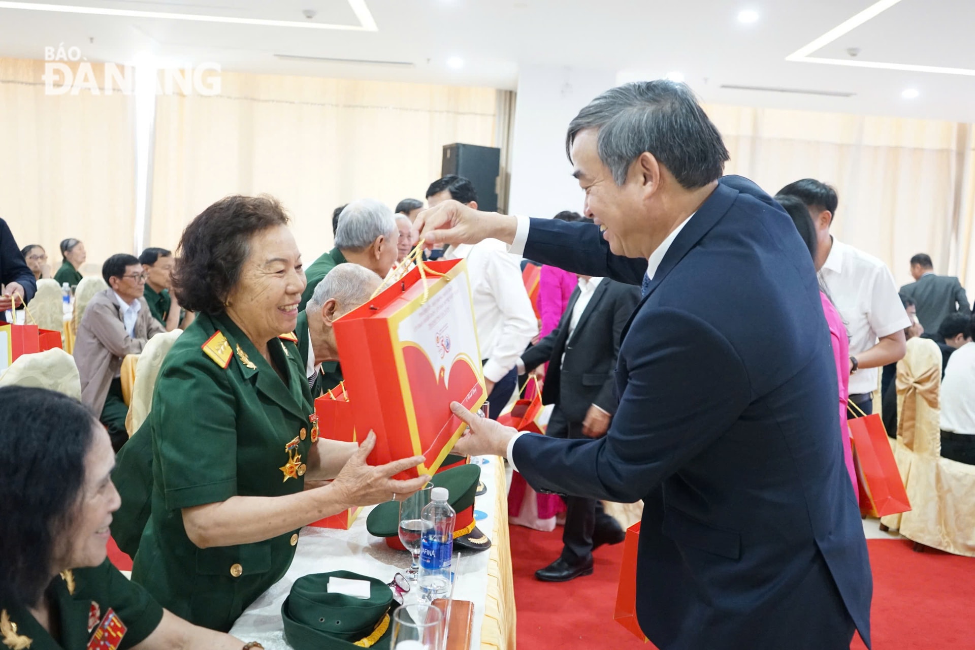 Chủ tịch UBND thành phố Lê Trung Chinh (bên phải) tặng quà cho người có công với cách mạng. Ảnh: L.P