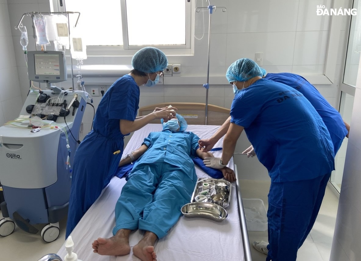 Các bác sĩ Khoa Nội thần kinh - cơ xương khớp - huyết học lâm sàng (Bệnh viện Đà Nẵng) kiểm tra sức khỏe cho bệnh nhân H.T.N. Ảnh: LÊ HÙNG