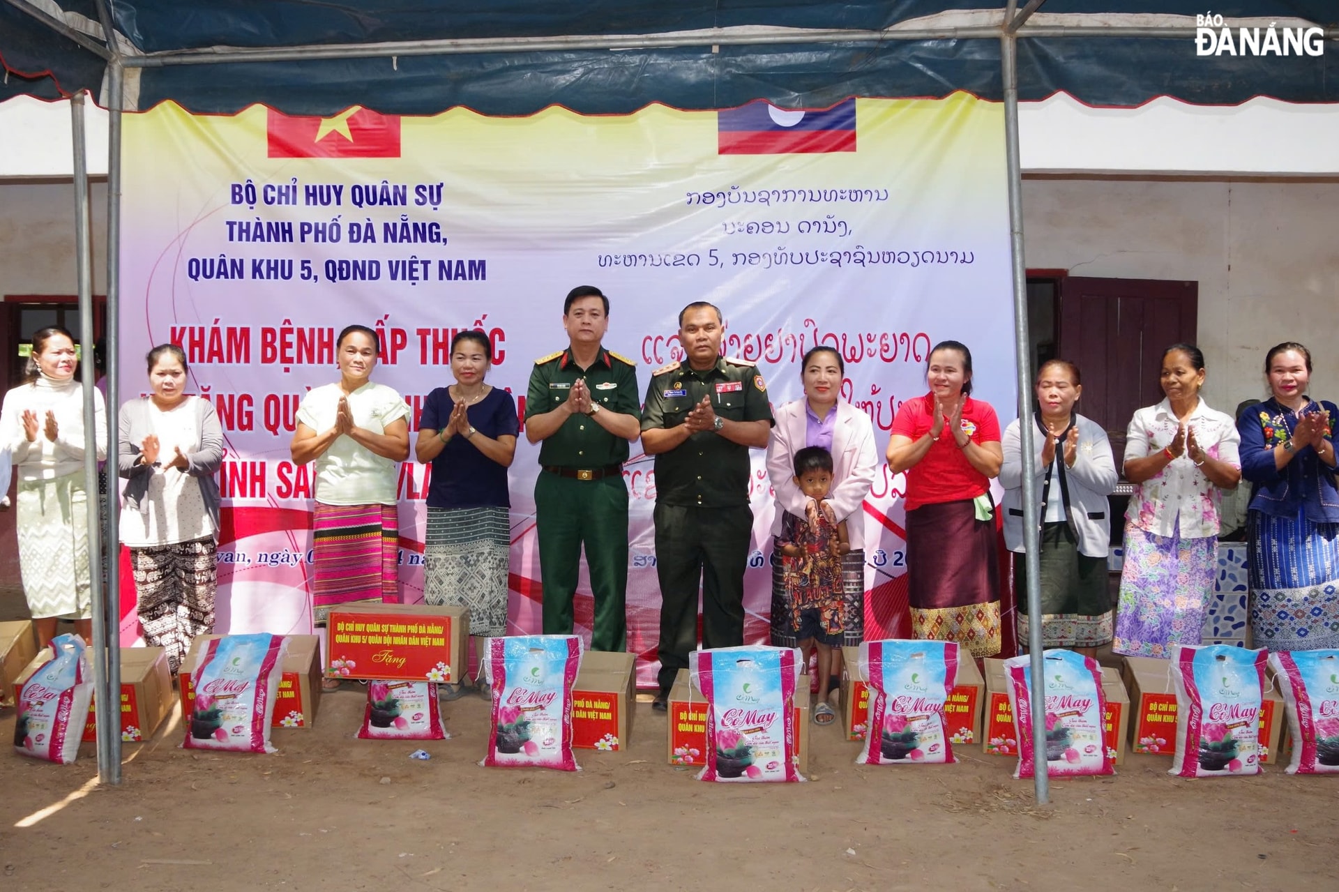 Đại tá Võ Văn Tuấn và lãnh đạo Bộ Chỉ huy Quân sự tỉnh Salavan tặng quà cho các gia đình khó khăn. Ảnh: HOÀNG TUẤN