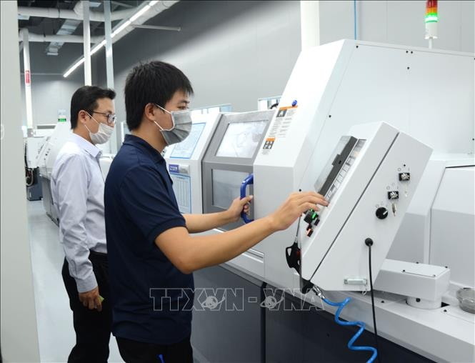 Công nhân vận hành máy sản xuất tại Công ty ICT Vina, Khu Công nghệ cao thành phố Đà Nẵng. Ảnh minh họa: TTXVN