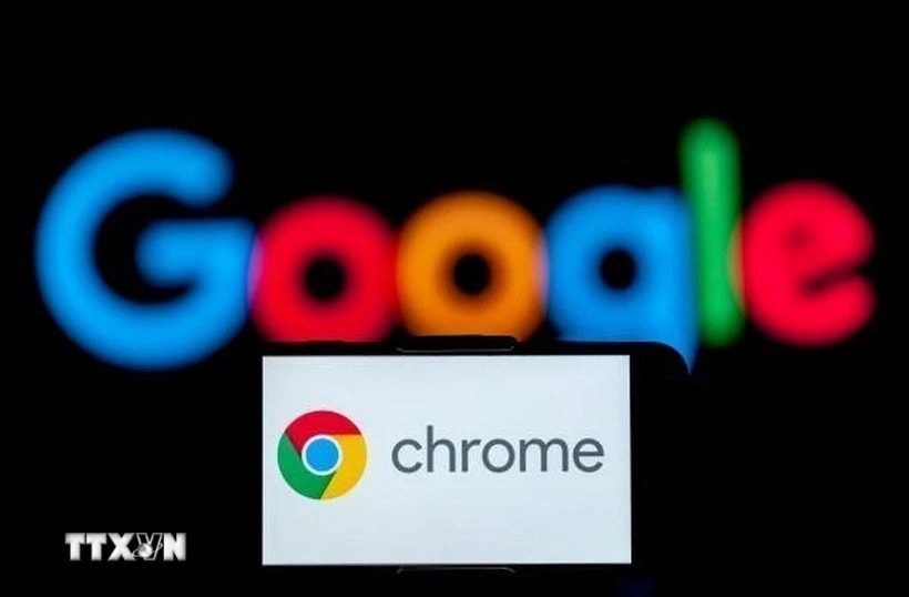 Biểu tượng Chrome trên màn hình điện thoại và biểu tượng Google (phía sau). (Ảnh: Getty Images/TTXVN)
