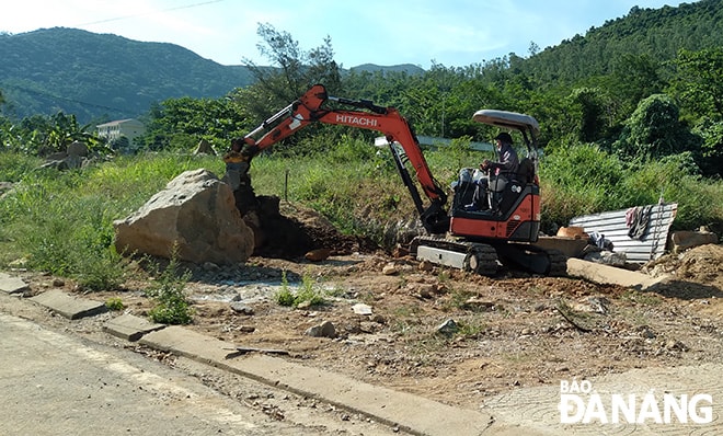 Các đơn vị sử dụng phương tiện cơ giới để khơi thông cửa thu nước mưa từ khu vực suối Đá xuống mương thoát nước dọc đường Lê Văn Lương (quận Sơn Trà). Ảnh: HOÀNG HIỆP