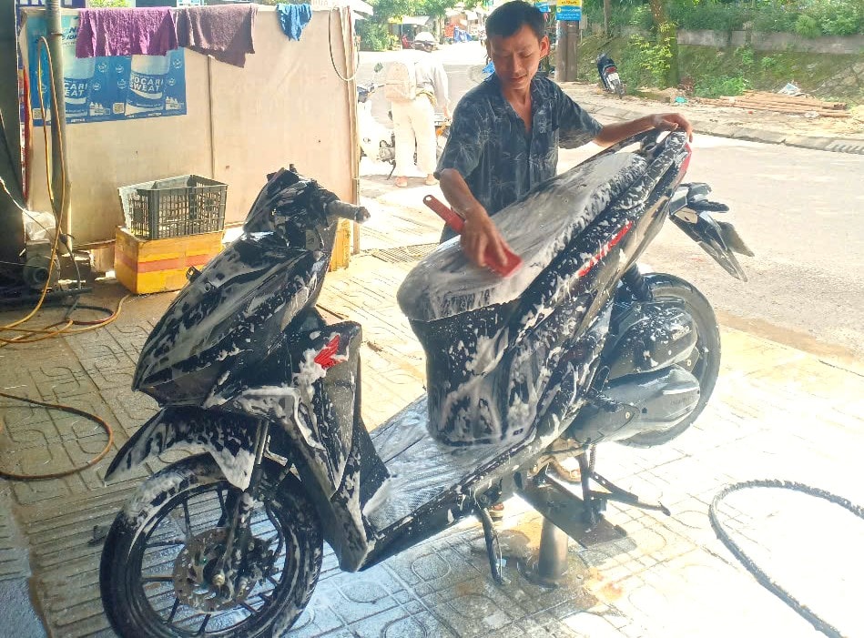 Công việc mưu sinh hằng ngày để lo cho gia đình anh Chánh là rửa xe thuê tại tổ Trung Thị thị trấn Trà My. BÌNH MINH