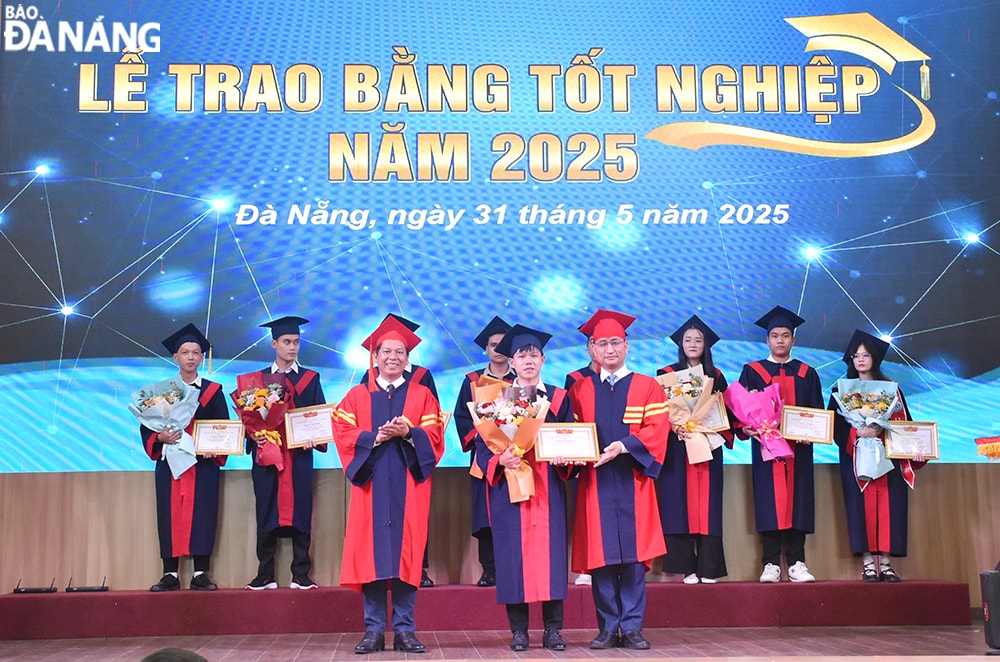 Đại diện lãnh đạo nhà trường khen thưởng cho các sinh viên tốt nghiệp loại xuất sắc. Ảnh: THU HÀ
