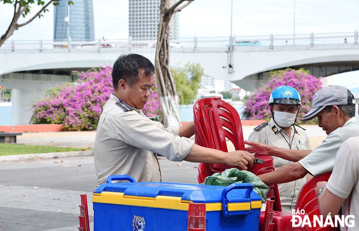 Lực lượng quy tắc đô thị quận Sơn Trà yêu cầu người dân không tụ tập, buôn bán khu vực dưới cầu Sông Hàn trong sáng 31-5. 