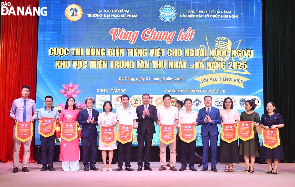 Phó Chủ tịch Thường trực UBND thành phố Hồ Kỳ Minh tặng cờ lưu niệm cho các đại diện tham dự tại cuộc thi. Ảnh: THU HÀ.