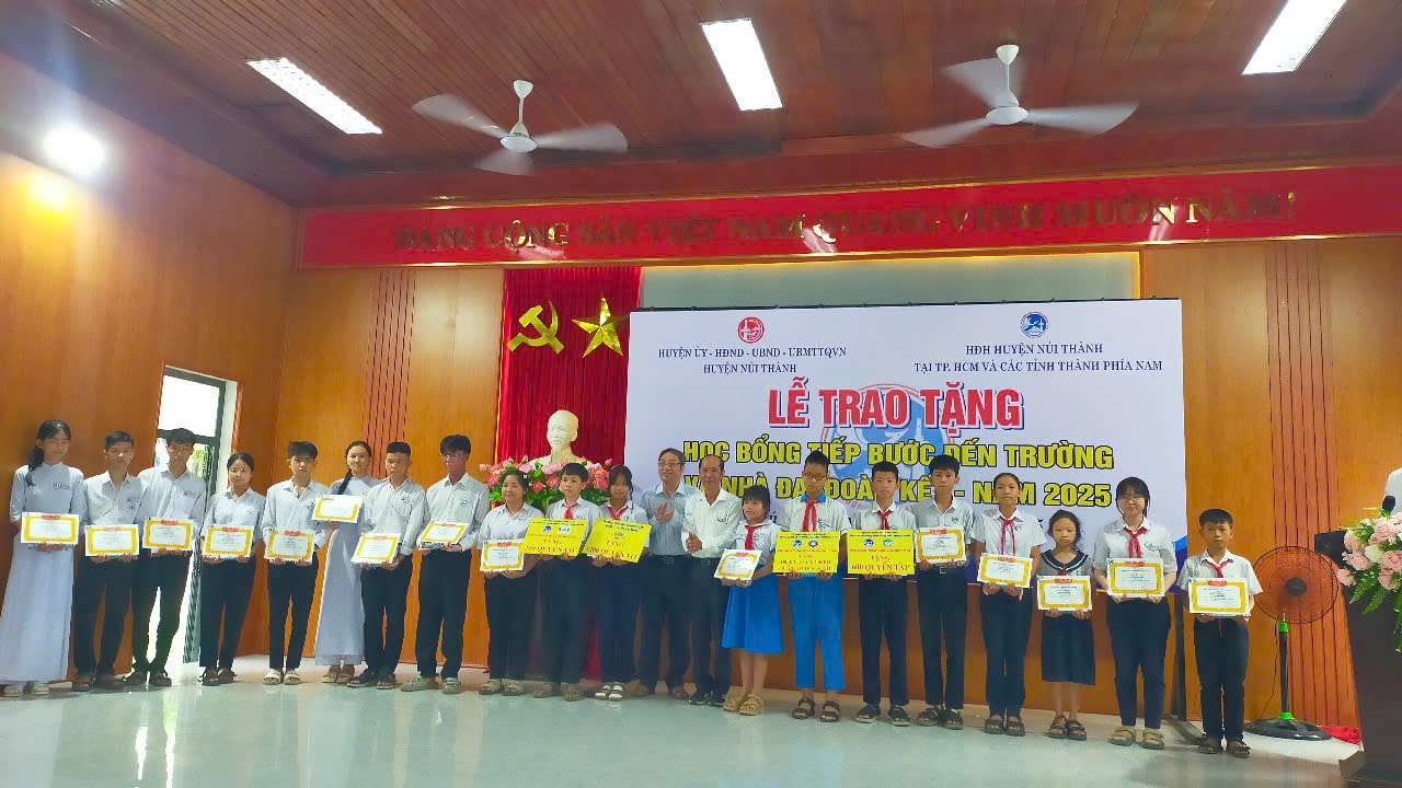 Ông Lê Văn Sinh Chủ tịch UBND huyện Núi Thành và đại diện Hội Đồng hương trao tặng học bỗng cho các em - ảnh LV Huân