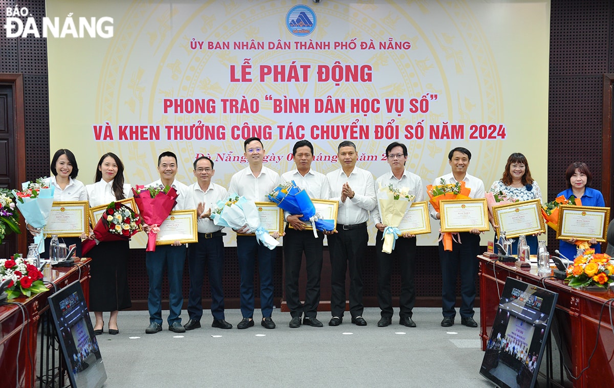 Phó Chủ tịch Thường trực UBND thành phố Hồ Kỳ Minh (thứ 5, từ phải sang) và lãnh đạo Sở Khoa học và Công nghệ trao bằng khen và tặng hoa chúc mừng các tập thể có thành tích xuất sắc trong công tác chuyển đổi số năm 2024. Ảnh: T.PHƯƠNG