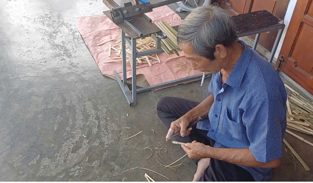 Ông Anh ngồi vót nan tre một cách tỉ mỉ. Ảnh: NGUYỄN QUỲNH