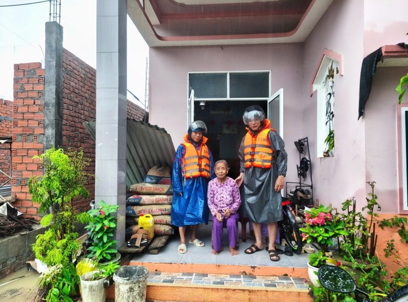 Lực lượng xung kích các địa phương dầm mưa để hỗ trợ dân di dời tài sản, đưa người già neo đơn đến nơi cao ráo, an toàn. Ảnh: Nguyễn Hoàng