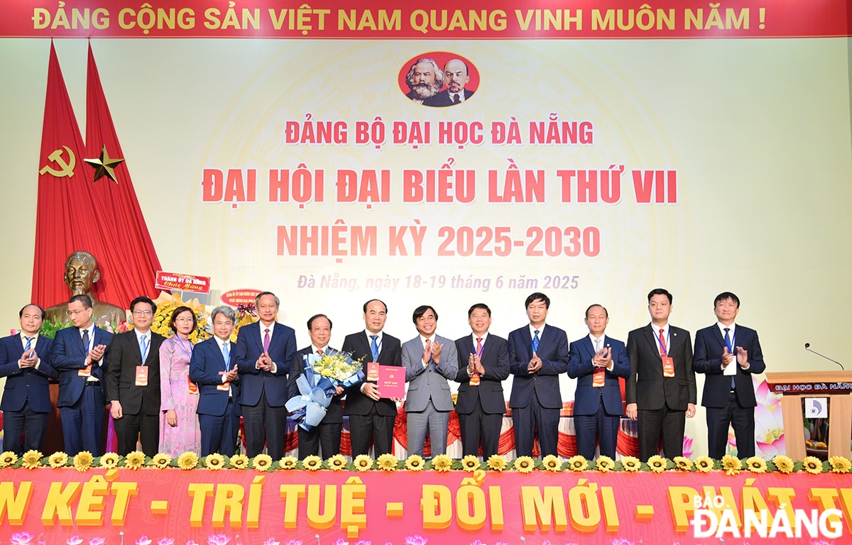 Phó Bí thư Đảng ủy UBND thành phố Tô Văn Hùng (thứ , từ phải sang) trao quyết định và Phó Chủ tịch HĐND thành phố Đoàn Ngọc Hùng Anh (thứ, từ trái sang) tặng hoa chúc mừng Ban Chấp hành Đảng bộ Đại học Đà Nẵng nhiệm kỳ 2025-2030. Ảnh: THIÊN AN