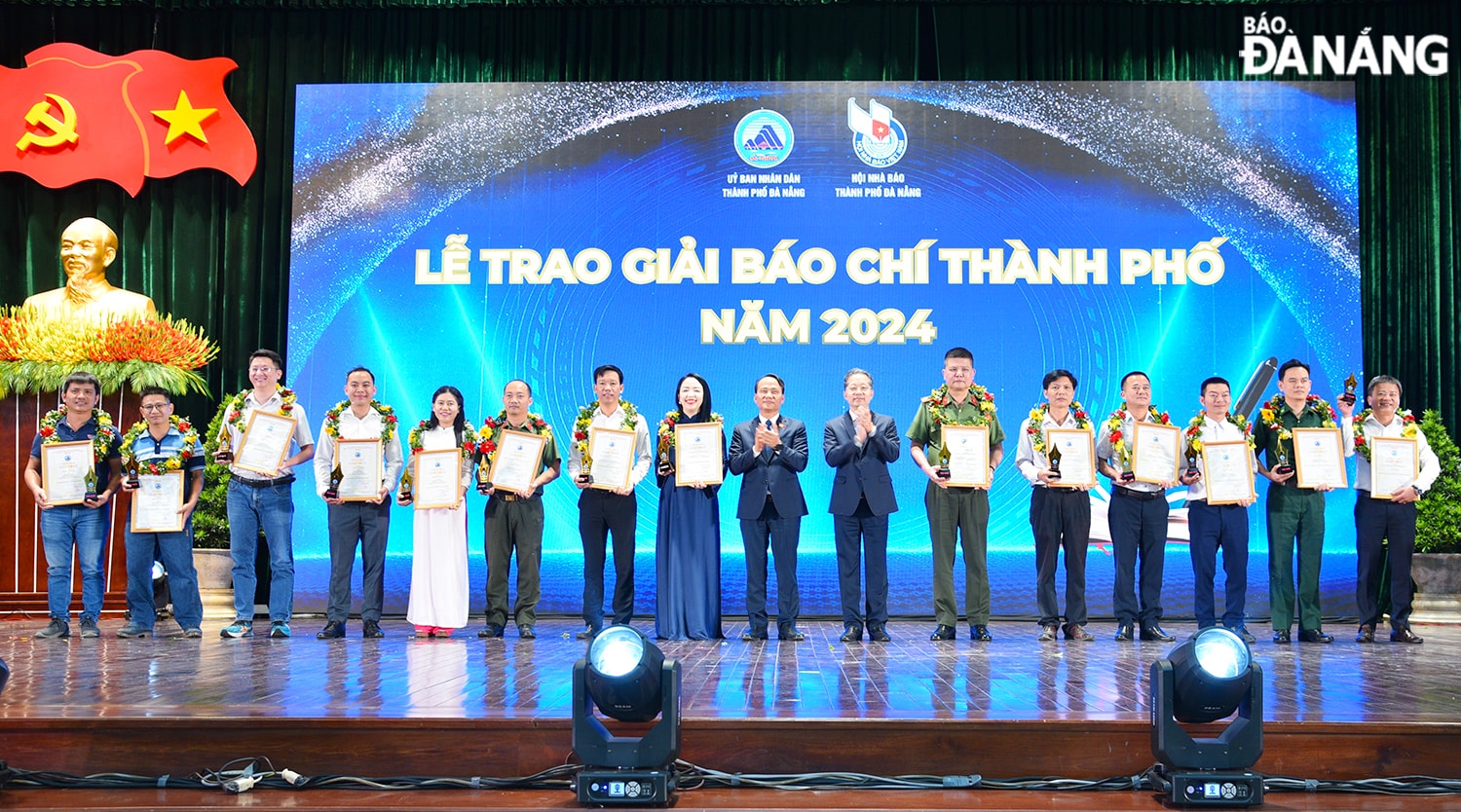 Bí thư Thành ủy Nguyễn Văn Quảng (thứ 7, từ phải sang), Phó Bí thư Thường trực Thành ủy Nguyễn Đình Vĩnh (thứ 9, từ trái sang) trao thưởng cho nhóm tác giả đoạt giải Nhất. Ảnh: T.PHƯƠNG