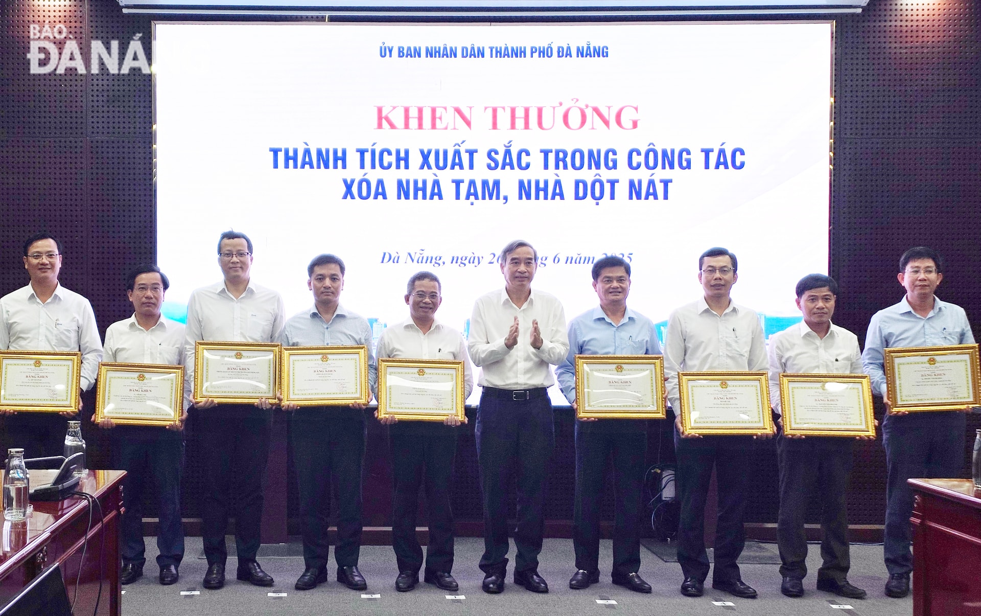 Chủ tịch UBND thành phố Lê Trung Chinh () trao bằng khen cho các tập thể, cá nhân có thành tích xuất sắc trong công tác xóa nhà tạm, nhà dột nát. Ảnh: LAM PHƯƠNG