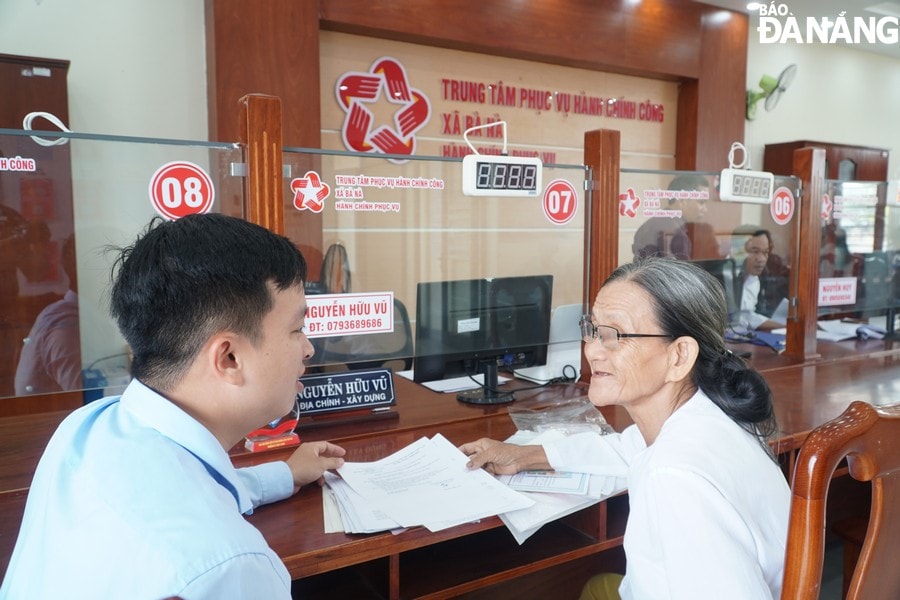 Người cao tuổi được cán bộ Trung tâm phục vụ hành chính công hỗ trợ các thủ tục về đất đai
