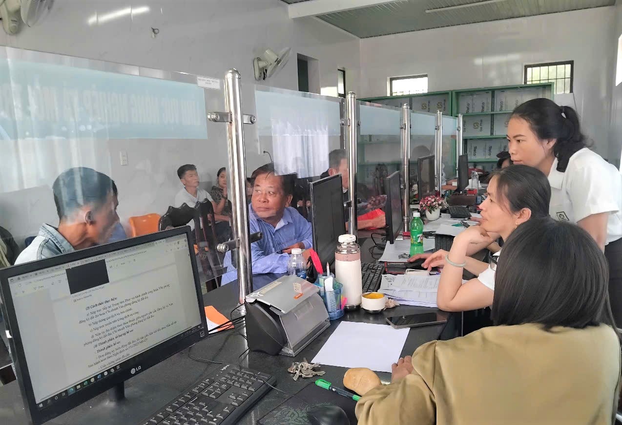 Cán bộ công chức, viên chức của Trung tâm Phục vụ hành chính công xã Thăng Điền hỗ trợ công dân giải quyết thủ tục hành chính. Ảnh: GIANG BIÊN