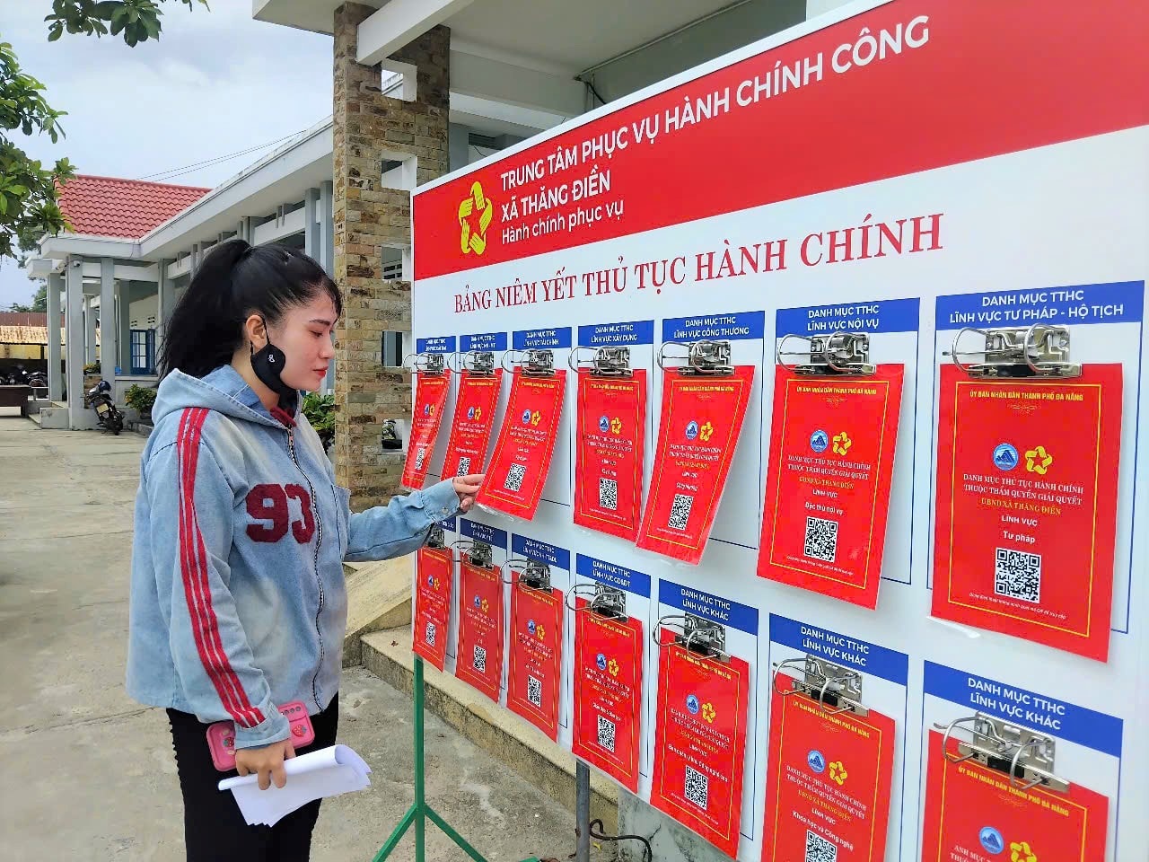 Trung tâm Phục vụ hành chính công xã Thăng Điền niêm yết 14 bộ thủ tục hành chính thuộc thẩm quyền thành phố, cho phép người dân quét mã QR tra cứu theo từng lĩnh vực để hoàn thiện hồ sơ. Ảnh: GIANG BIÊN
