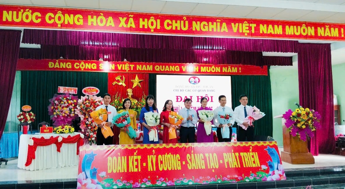 Ông Nguyễn Hữu Vĩnh tặng hoa chúc mừng Ban Chấp hành Chi bộ các cơ quan Đảng xã. Ảnh: KHẢI KHIÊM