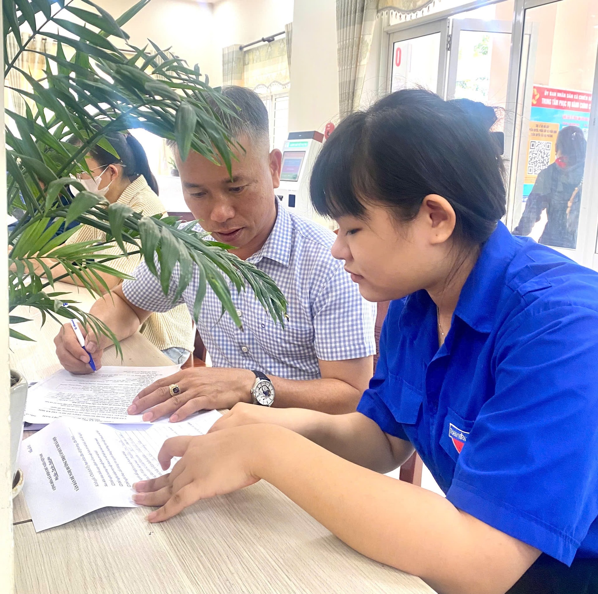 Người hoạt động không chuyên trách xã Chiên Đàn hướng dẫn người dân thực hiện thủ tục hành chính tại Trung tâm Phục vụ hành chính công xã. Ảnh: H.GIANG