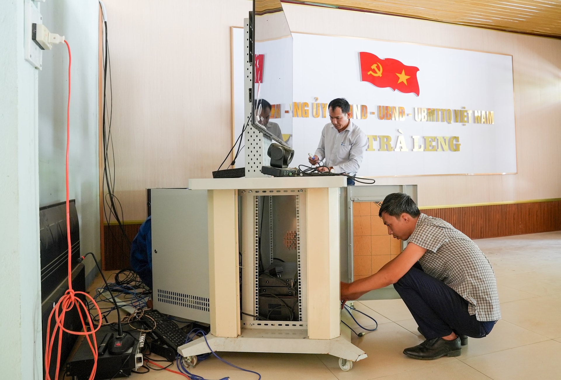 Cán bộ xã Trà Leng nỗ lực khôi phục hệ thống họp trực tuyến bị hư hỏng. Ảnh: HỒ QUÂN