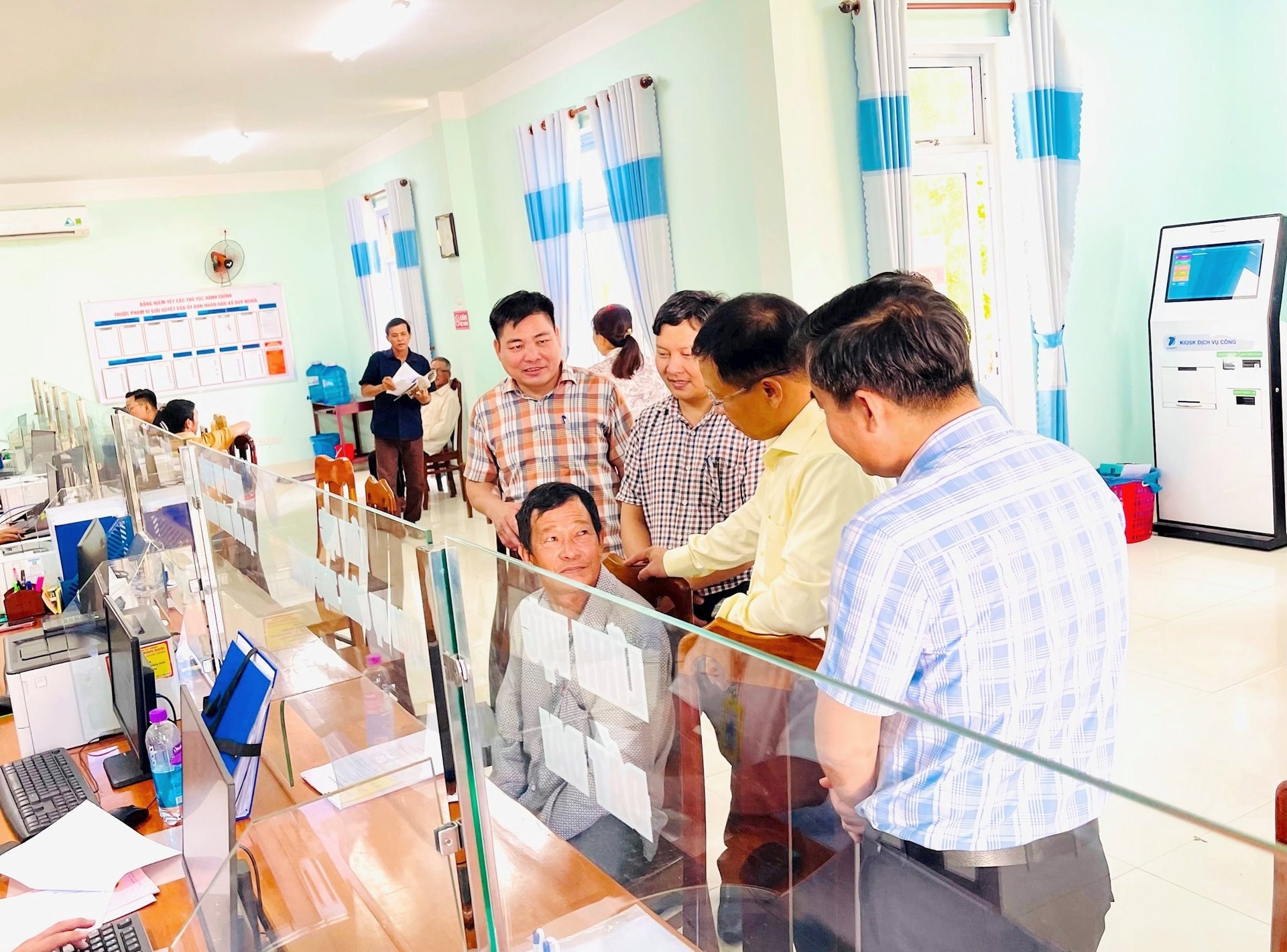 Trưởng ban Tổ chức Thành ủy Đoàn Duy Tân thăm hỏi người dân đến giải quyết thủ tục hành chính tại Trung tâm Phục vụ hành chính công xã Duy Nghĩa. Ảnh: TUYẾT MAI