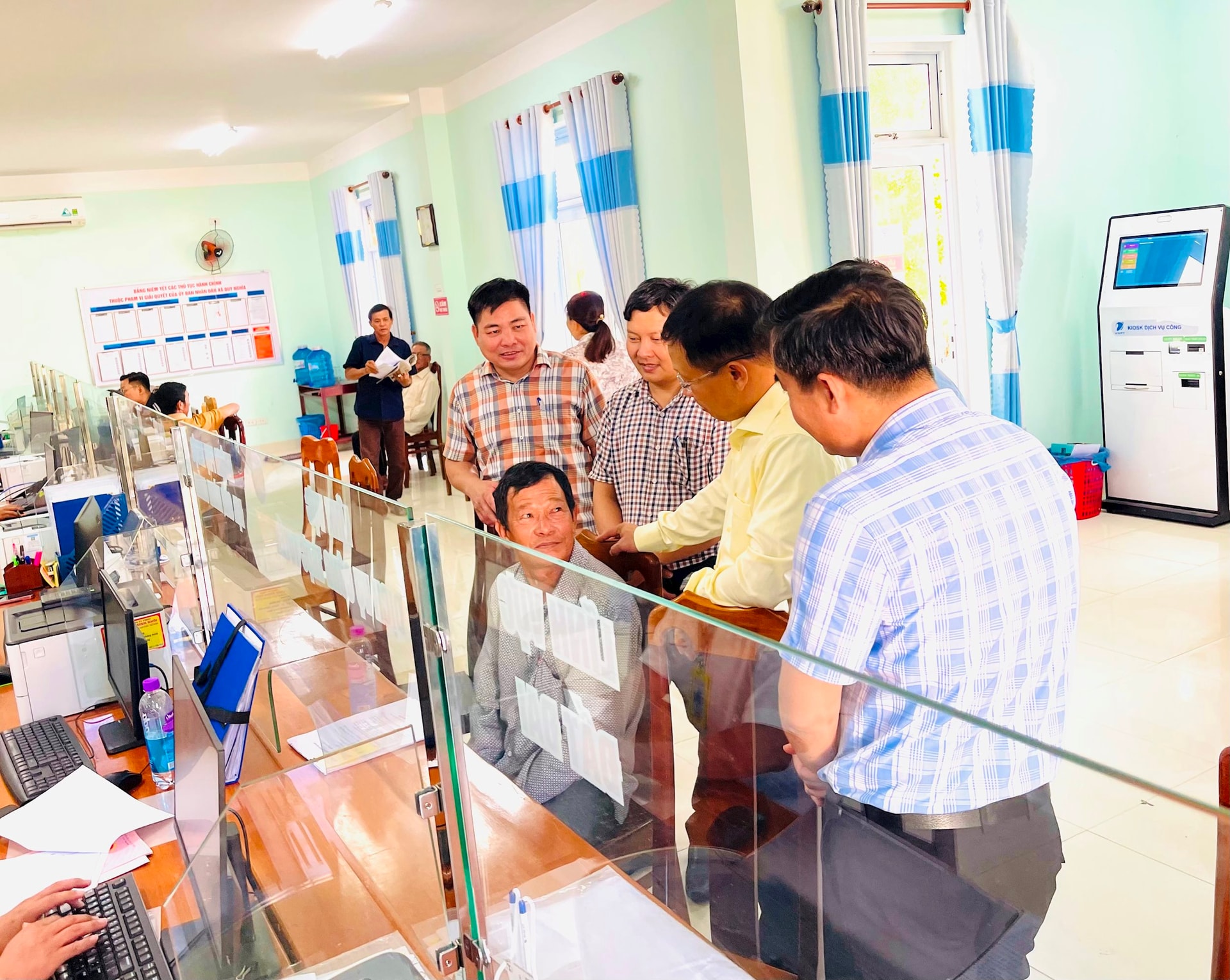 Trưởng ban tổ chức thành ủy Đoàn Duy Tân thăm hỏi nhân dân đến làm việc tại Trung tâm phục vụ hành chính công ã Duy Nghĩa. Ảnh: TUYẾT MAI