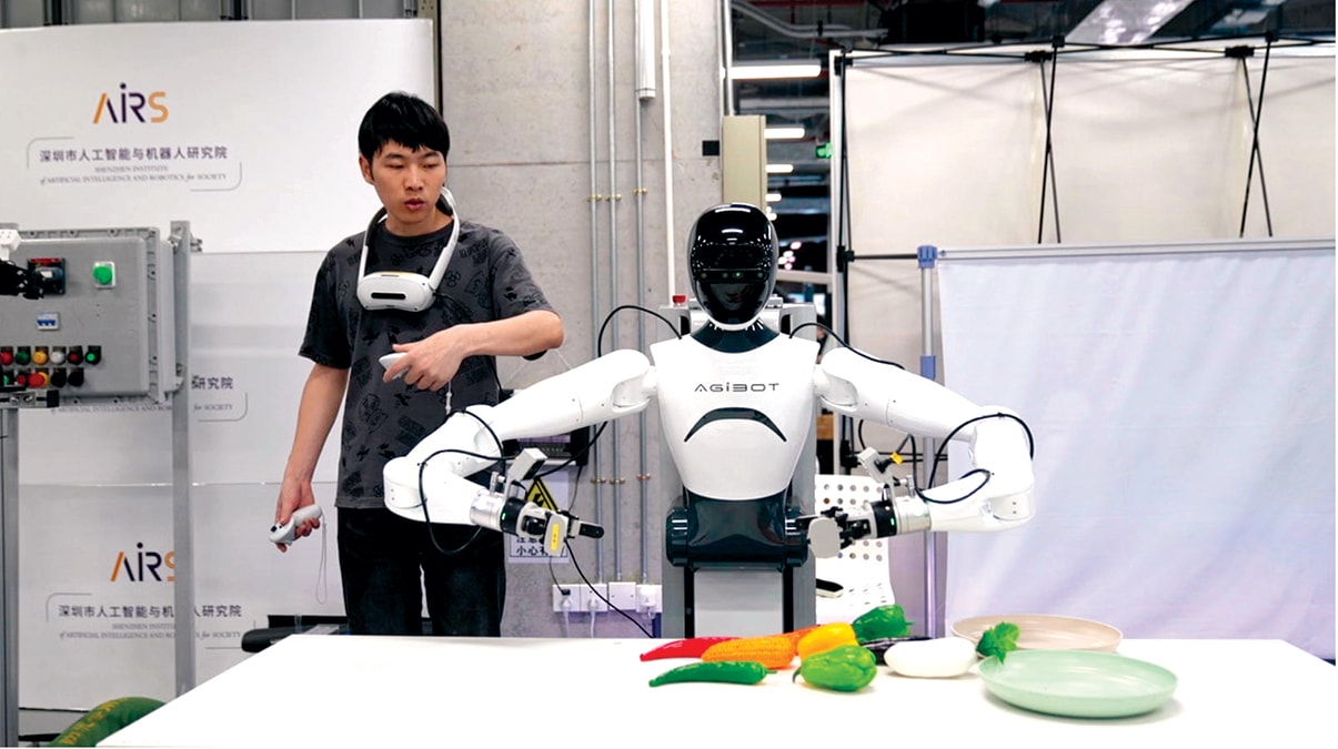 Một công nhân sử dụng robot để gắp đồ vật tại Thâm Quyến, ngày 25/6/2025. Ảnh: CGTN