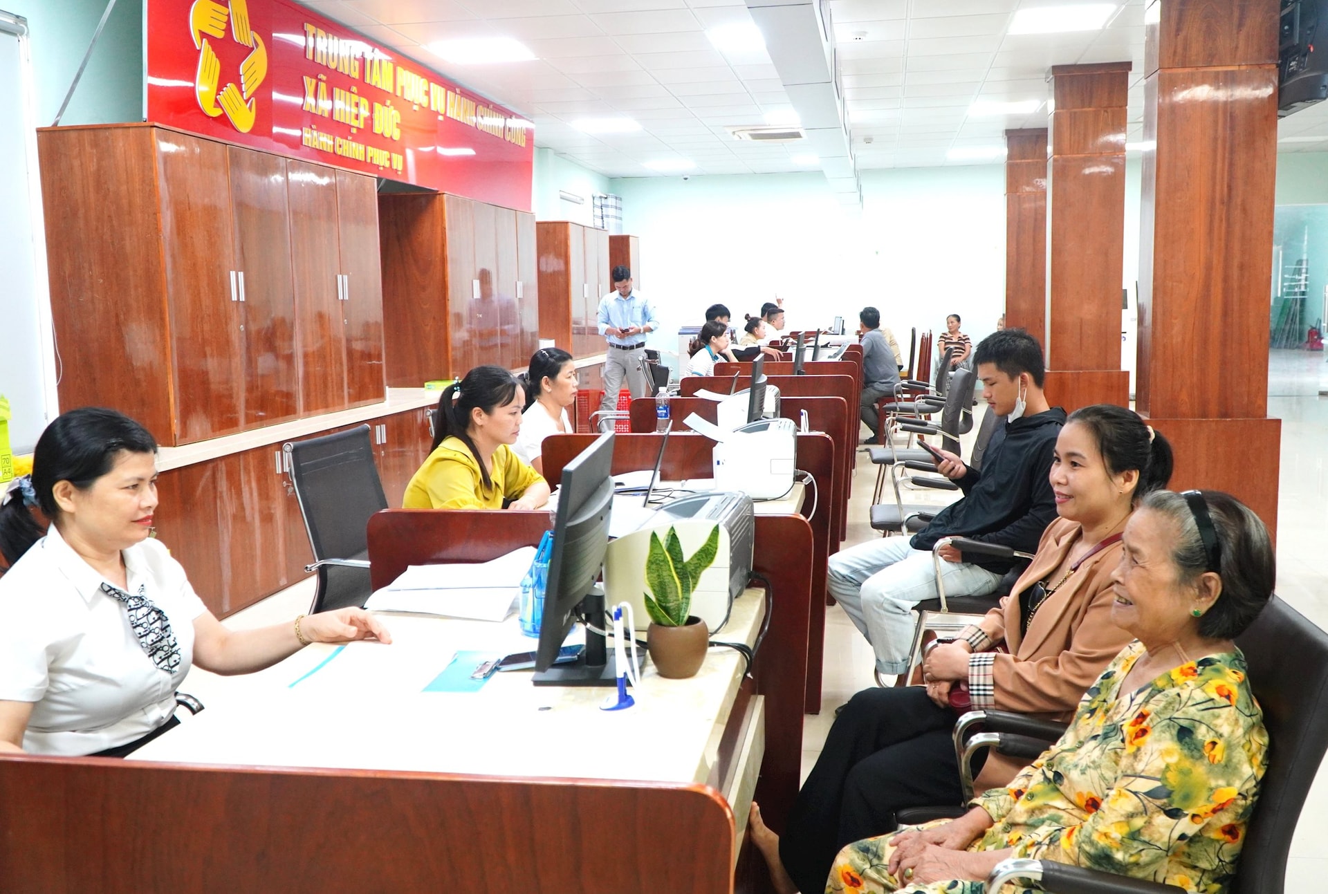 Công dân đi làm thủ tục hành chính tại Trung tâm Phục vụ hành chính công xã Hiệp Đức. Ảnh: VINH ANH