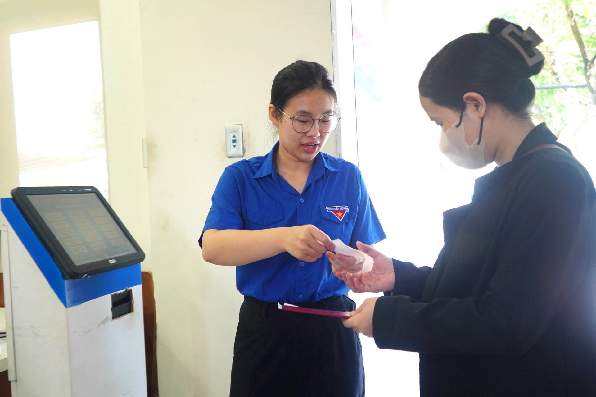 Thanh niên phường Tam Kỳ hỗ trợ người dân làm thủ tục hành chính tại Trung tâm Phục vụ hành chính công. Ảnh: VINH ANH