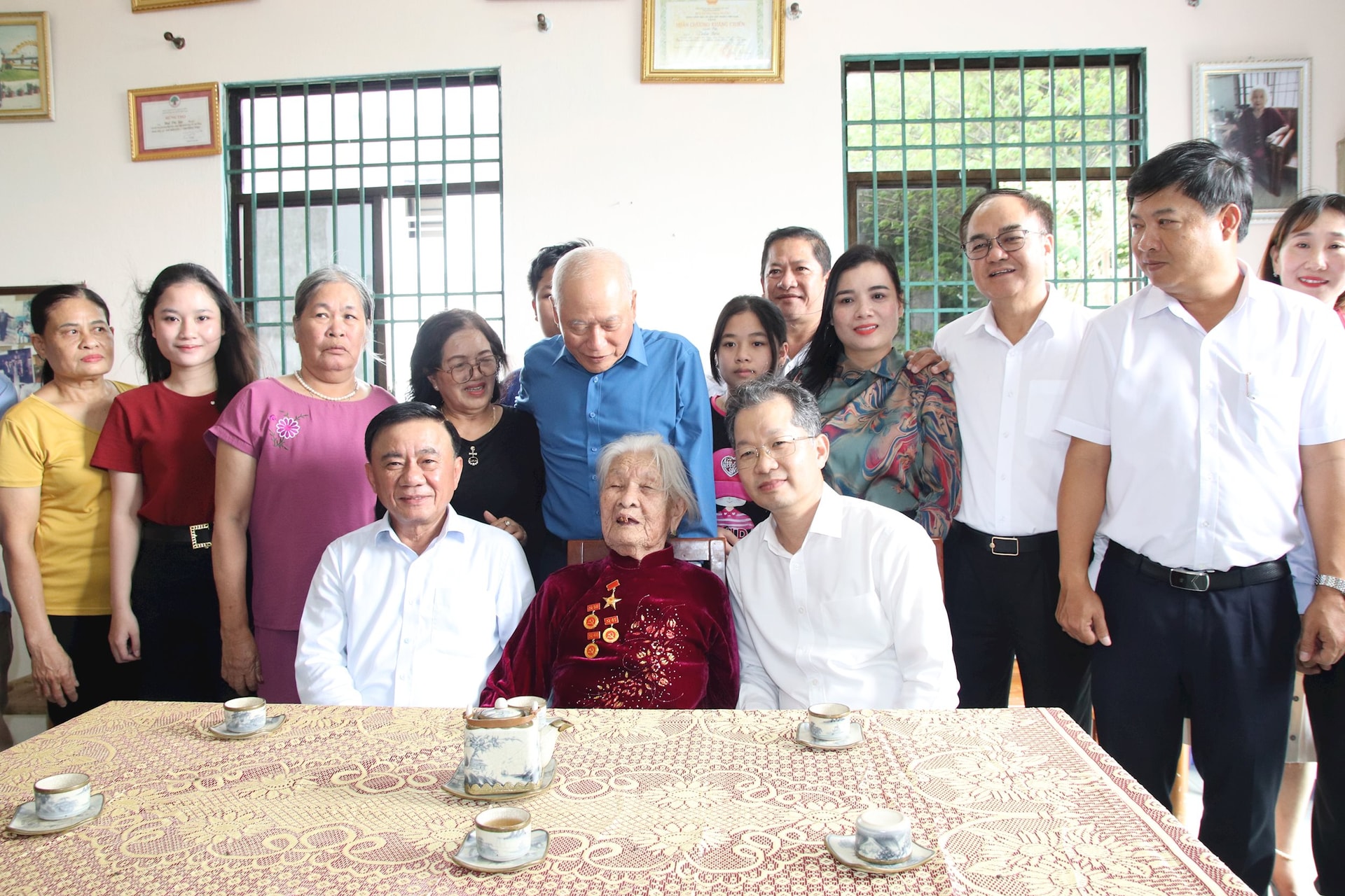 Thường trực Ban Bí thư Trung ương Đảng Trần Cẩm Tú, Bí thư Thành ủy Nguyễn Văn Quảng cùng đoàn công tác chụp ảnh lưu niệm với mẹ Mai Thị Sây và gia đình. Ảnh: TRỌNG H