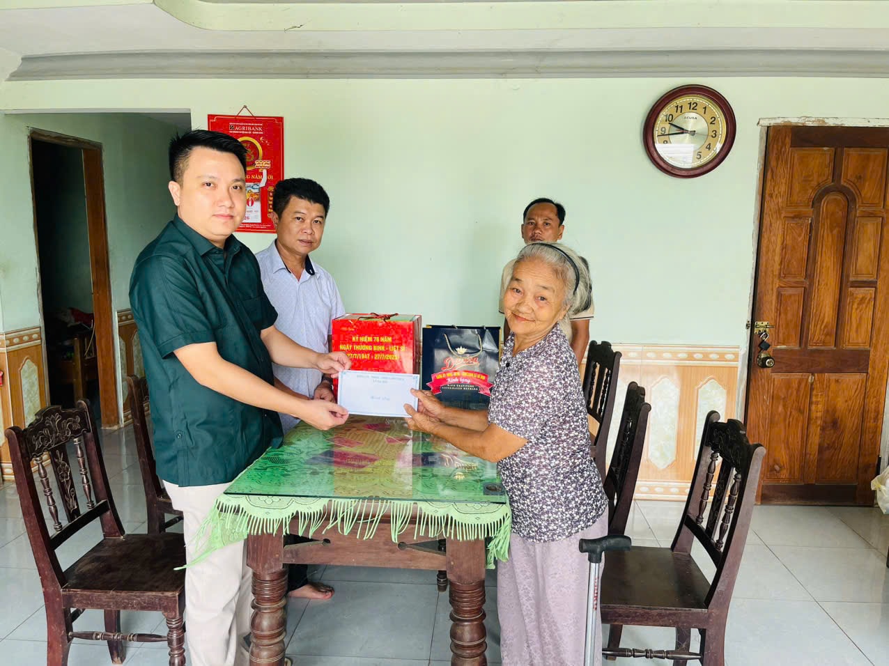 Ông Mai Thanh Sang - Chủ tịch UBND xã Hà Nha thăm hỏi, tặng quà mẹ Hứa Thị Lau (thân nhân liệt sĩ ở thôn Phước Lâm). Ảnh: CÔNG TÚ