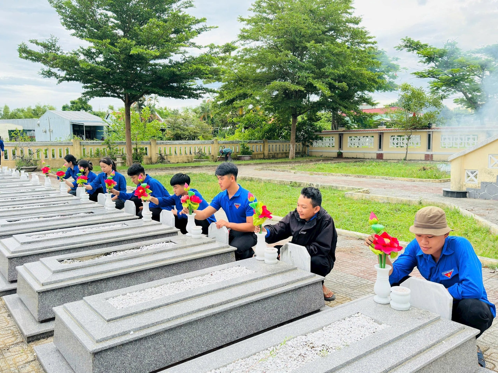 Mitglieder der Jugendunion des Bezirks Dien Ban Dong beteiligen sich an der Renovierung der Märtyrergräber auf dem örtlichen Friedhof. Foto: X.HAU
