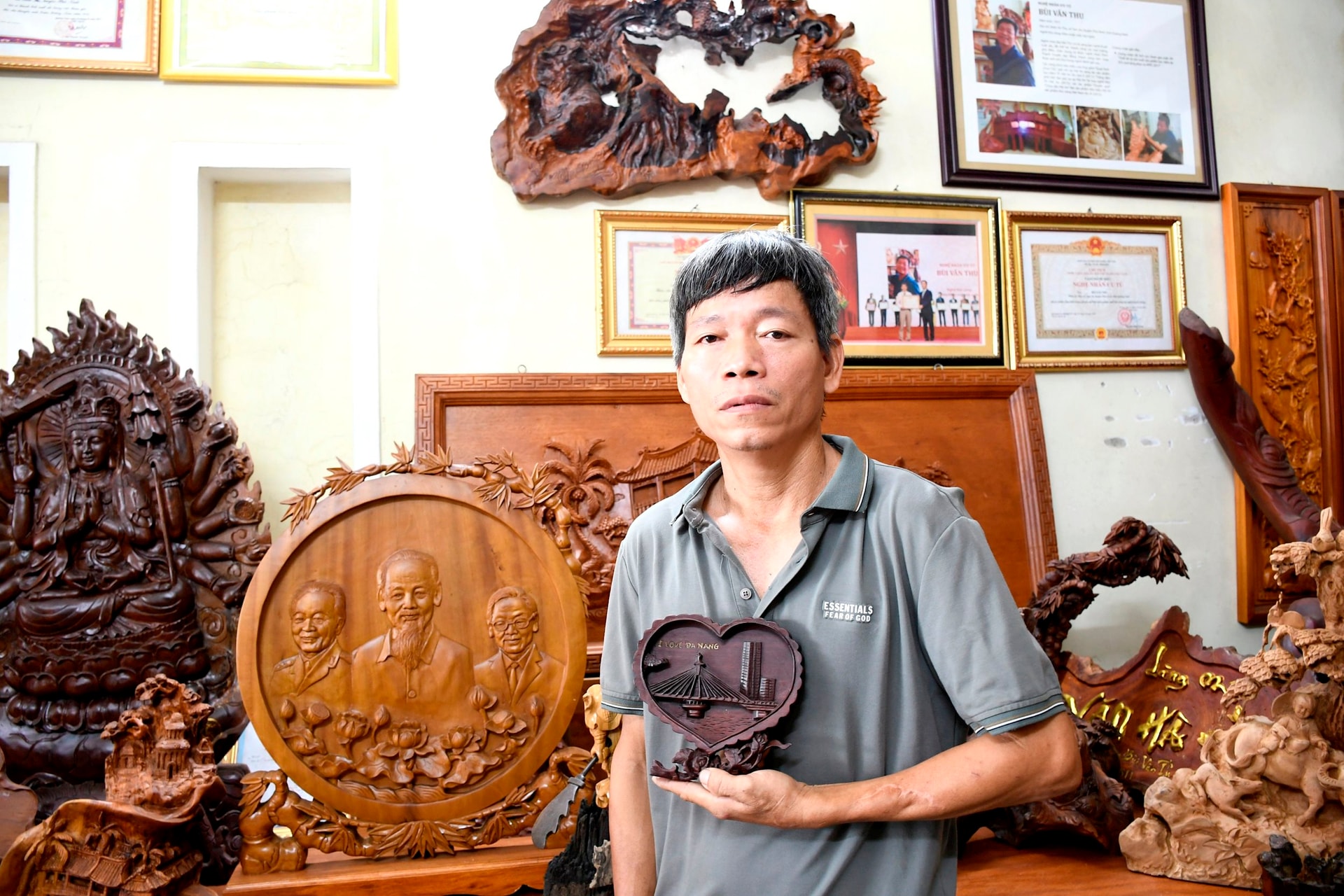 Nghệ nhân ưu tú Bùi Văn thu bên tác phẩm Đà Nẵng mến yêu. Ảnh: QUANG VIÊT