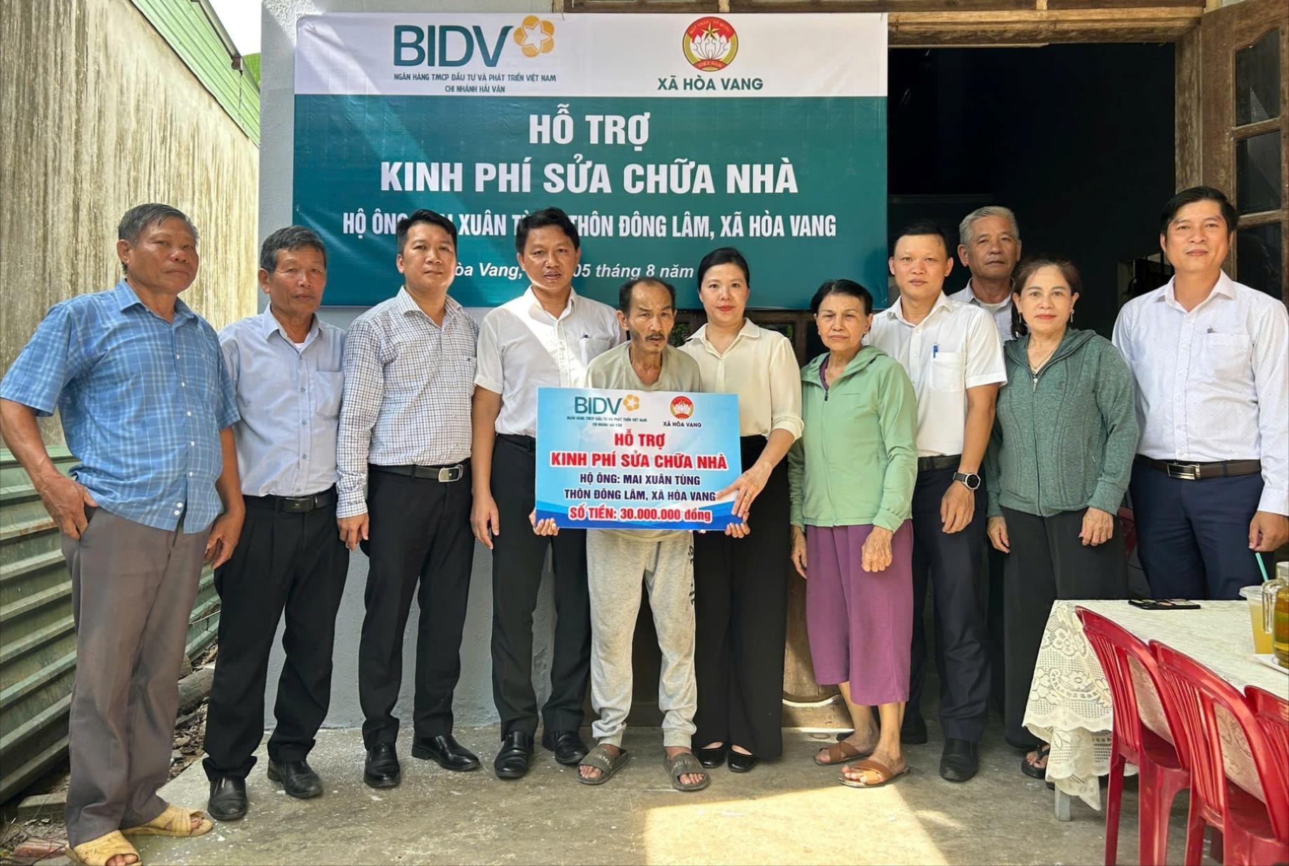 Đại diện Ngân hàng BIDV - Chi nhánh Hải Vân và xã Hòa Vang trao kinh phí hỗ trợ sửa chữa nhà cho hộ nghèo. Ảnh: LAM PHƯƠNG